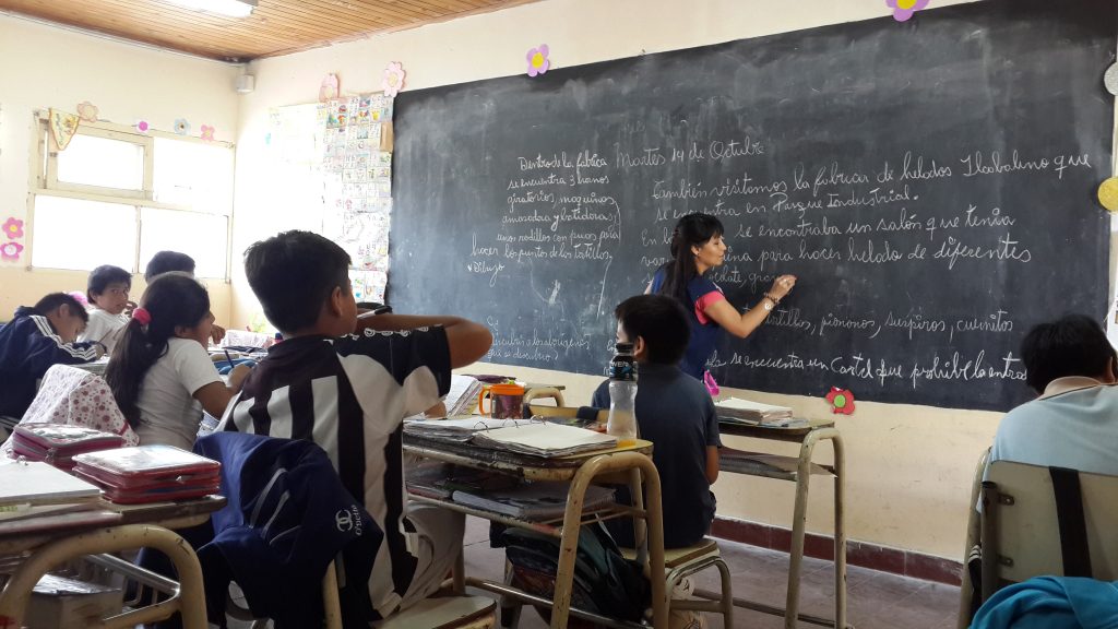 Maestra escribiendo en el pizarrón