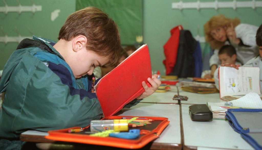 Alumno de primaria de la Escuela Abel Ayerza en us primer día de clases luego de las vacaciones de verano. Estudiando con su cuaderno rojo